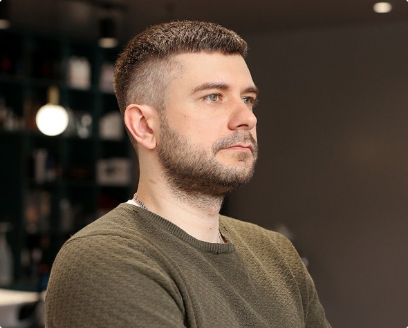 Men’s haircut with smooth faded sides and naturally styled top after a haircut in Warsaw